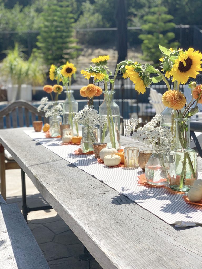 backyard table decorated with sunflowers for a fall outdoor dinner party