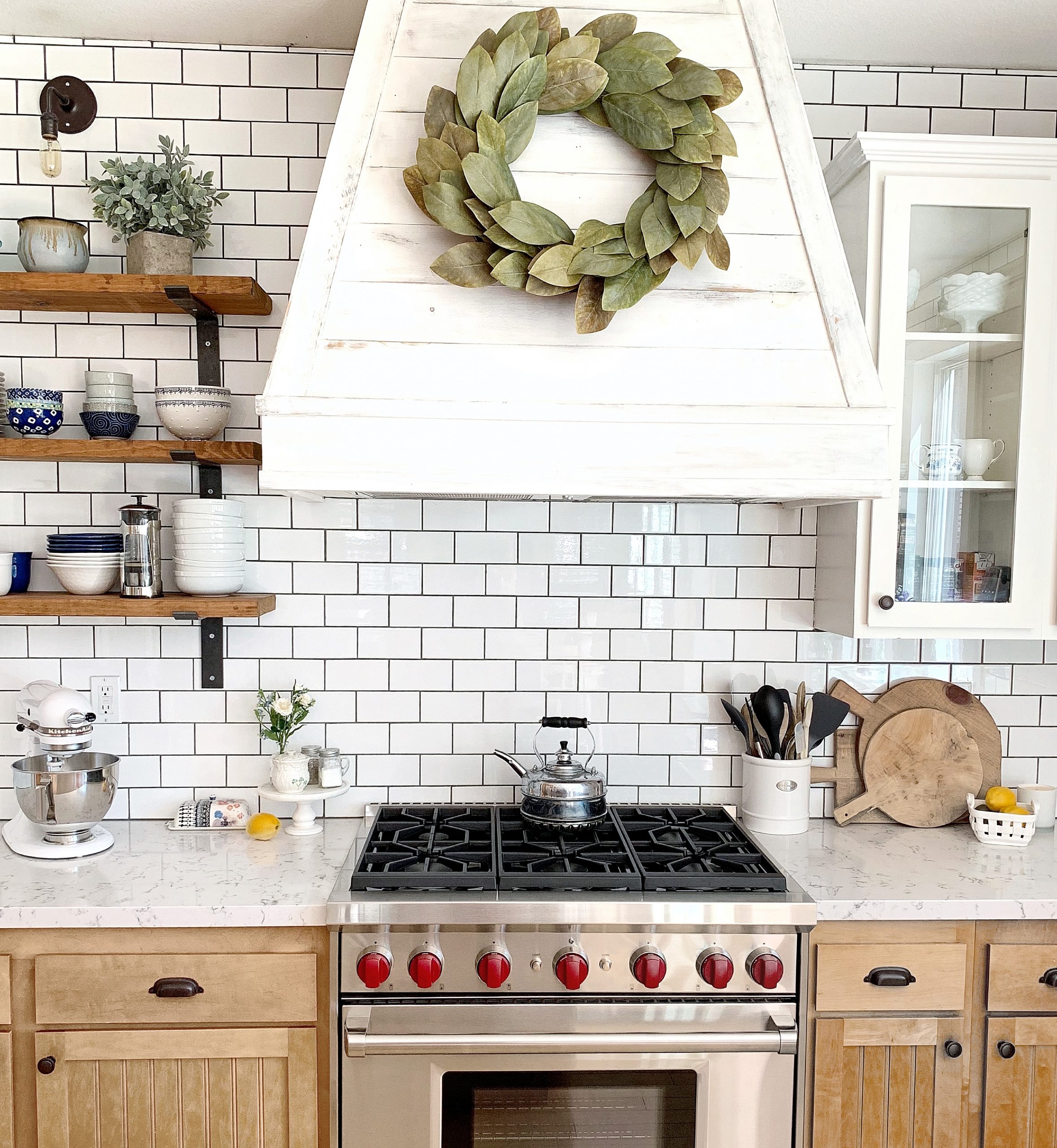 Full view of a kitchen remodel with Frazee white shadow paint, soapstone countertops, white lyra quartz countertops, white subway tile and open shelves.