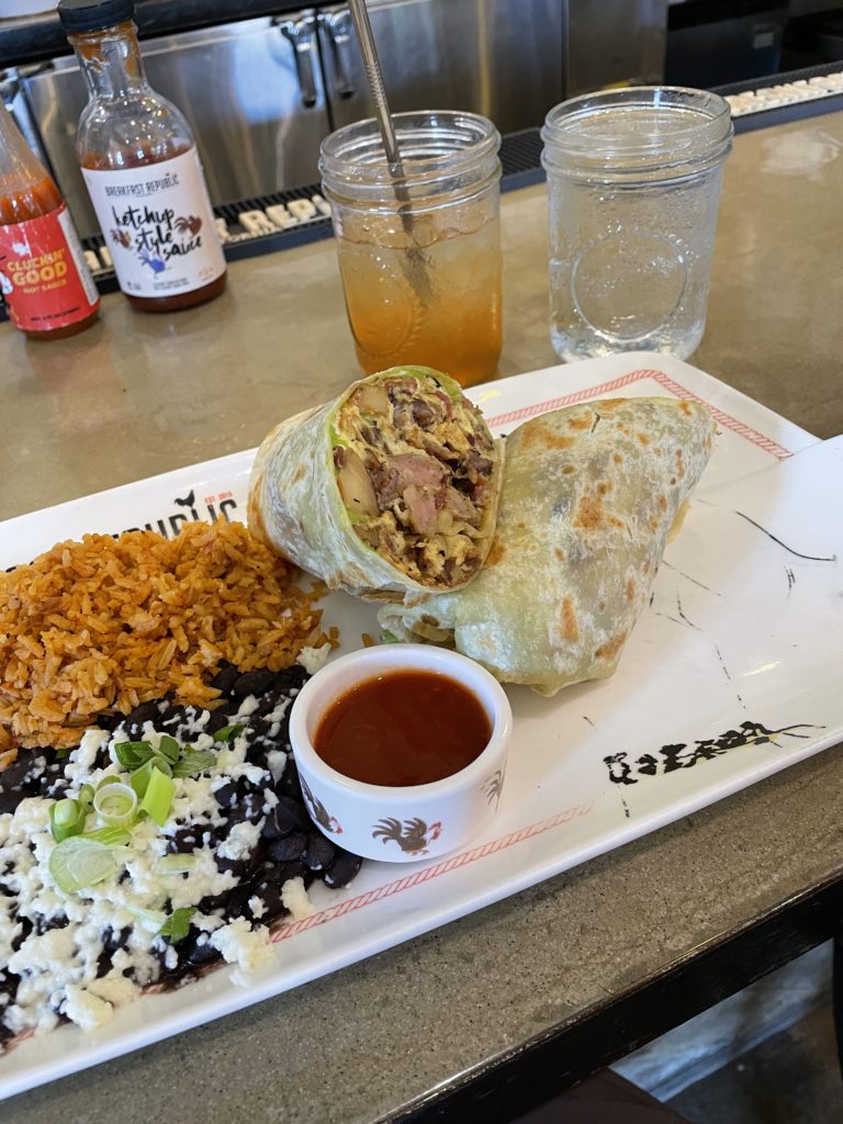 Breakfast burrito and rice on a plate at Breakfast republic at Liberty station in san diego california