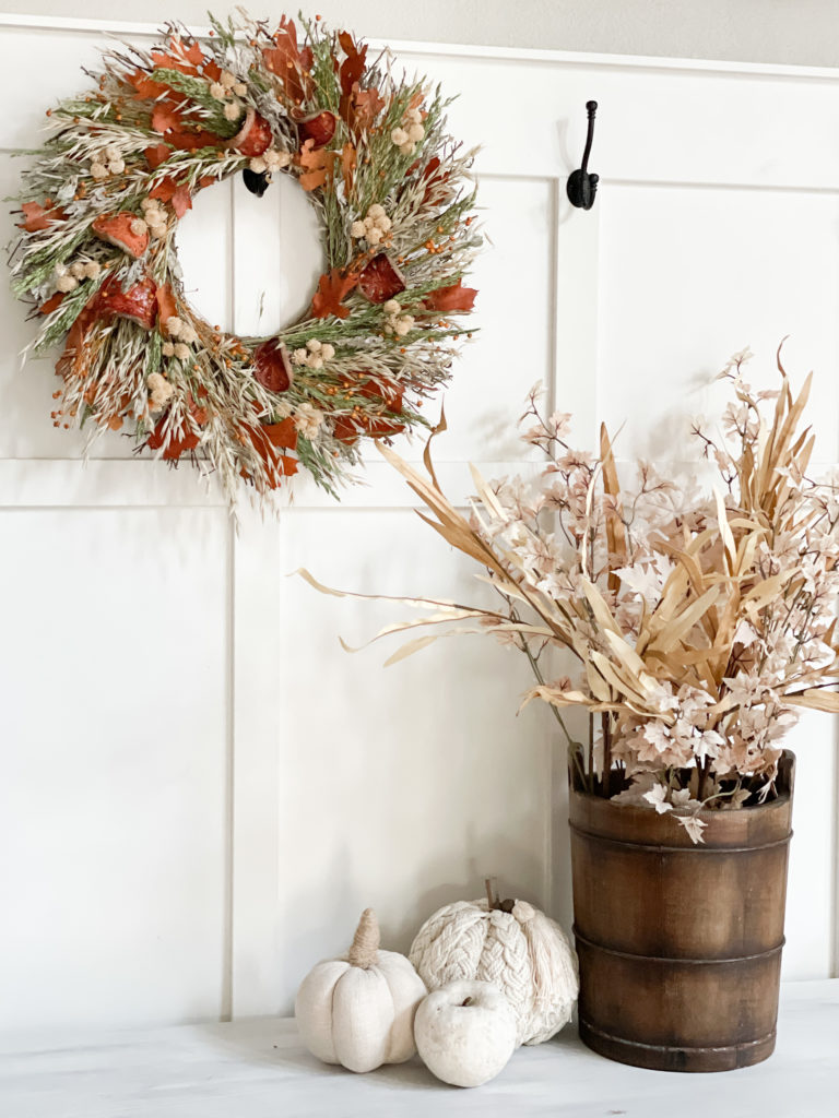Frazee white shadow paint in a front entryway with board and batten and fall wreath and fall pumpkins and a vintage ice cream bucket with faux stems