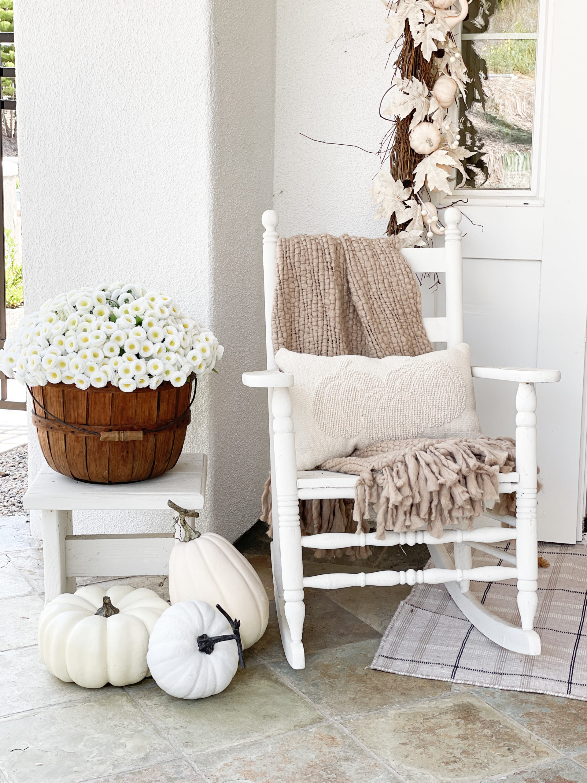 A welcoming fall porch with tips on how to make your front porch cozy and inviting using fall pillows, garlands, throws, and signs. House color is Sherwin WIlliams Pure White and Sherwin Williams Gauntlet Gray