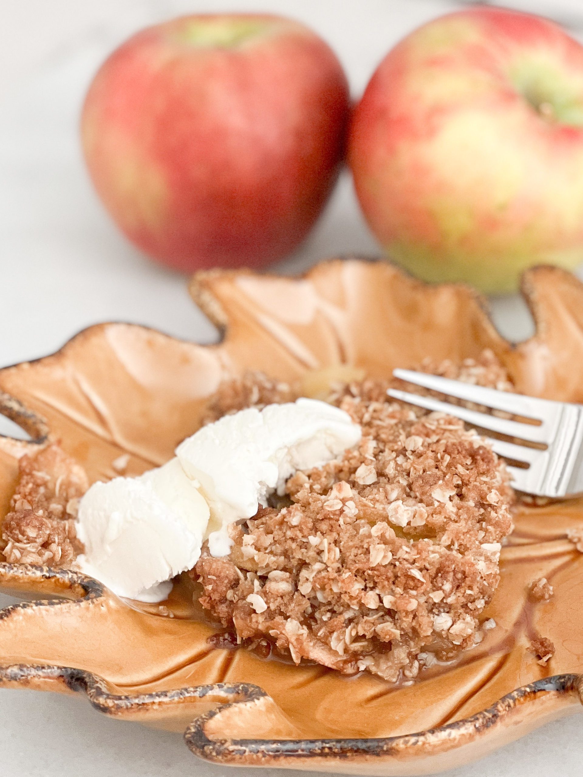 A perfect and easy fall apple crisp recipe. Top apples with a brown sugar and oats topping and ice cream for a delicious fall treat! Perfect for a fall dinner party. #applerecipes #fallrecipes #fallbaking #baking #recipes #appletreats #easyapplerecipes