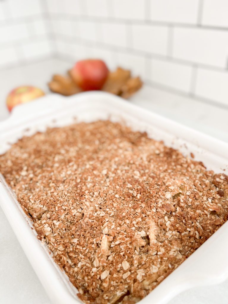 A perfect and easy fall apple crisp recipe. Top apples with a brown sugar and oats topping and ice cream for a delicious fall treat! Perfect for a fall dinner party. #applerecipes #fallrecipes #fallbaking #baking #recipes #appletreats #easyapplerecipes