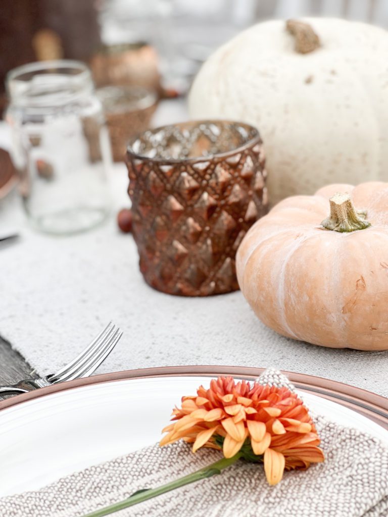 Ideas for a simple and welcoming Friendsgiving Tablescape using vintage decor, pumpkins, flowers, candles, and acorns. Can also be Thanksgiving tablescape ideas - especially an outdoor celebration! #falldecor #thanksgiving #friendsgiving #Thanksgivingtable #Friendsgivingtableideas