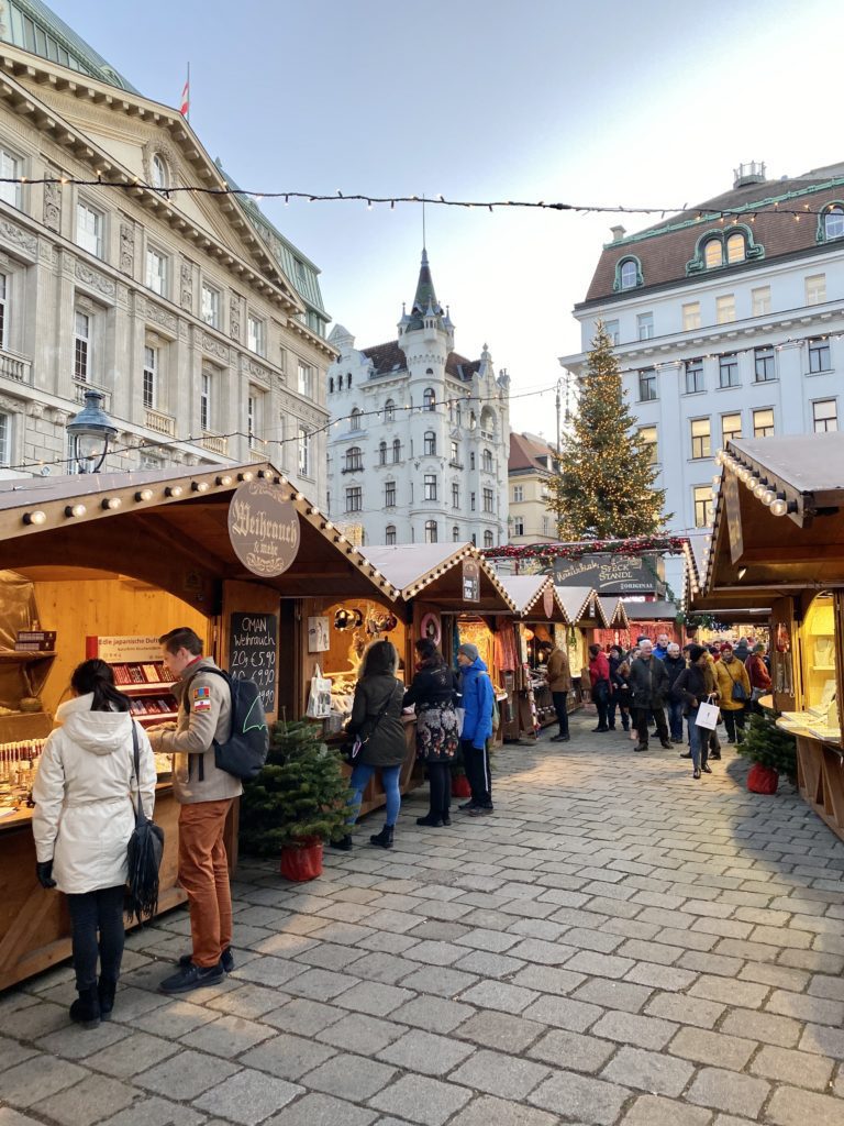 A Festive Travel Guide to Vienna at Christmas including where to stay in Vienna, where to eat in Vienna, and top things to do in Vienna.  You can also find a list of all the don't miss Vienna Christmas markets.  Our full itinerary included three days in Vienna with three days in Budapest, Hungary afterwards!  Photo is of a Christmas Market in Vienna.

#europeanchristmasmarkets #europeantravel #viennachristmasmarket #viennachristmas #christmasinvienna