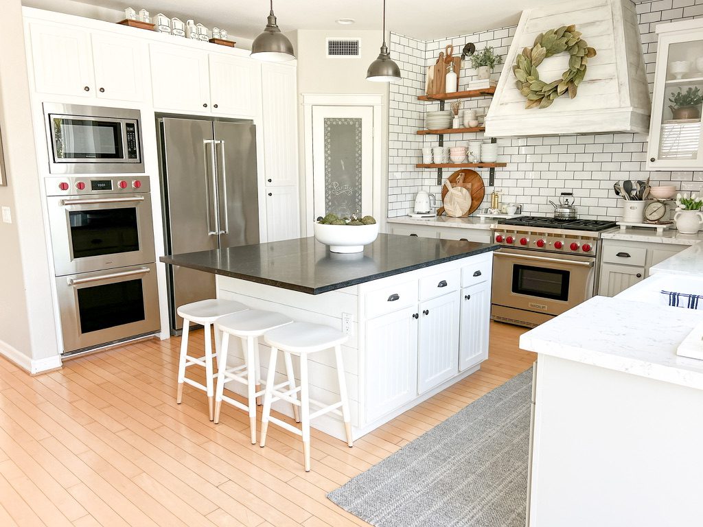 Sherwin williams pure white kitchen cabinets with soapstone counters and white lyra quartz countertops plus a wolf range
