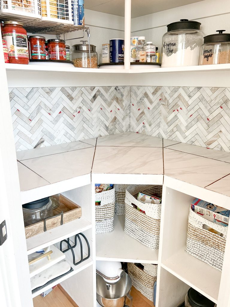 kitchen pantry remodel with marble backsplash and white tile counters