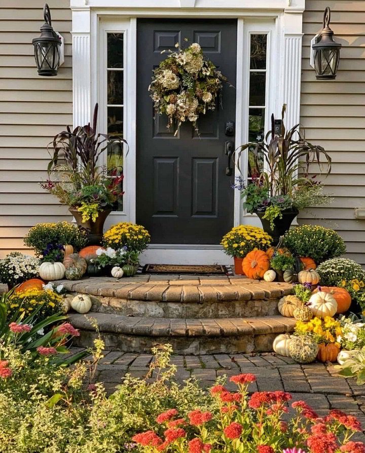 Front porch fall decor inspiration with pumpkins and gourds on brick patio