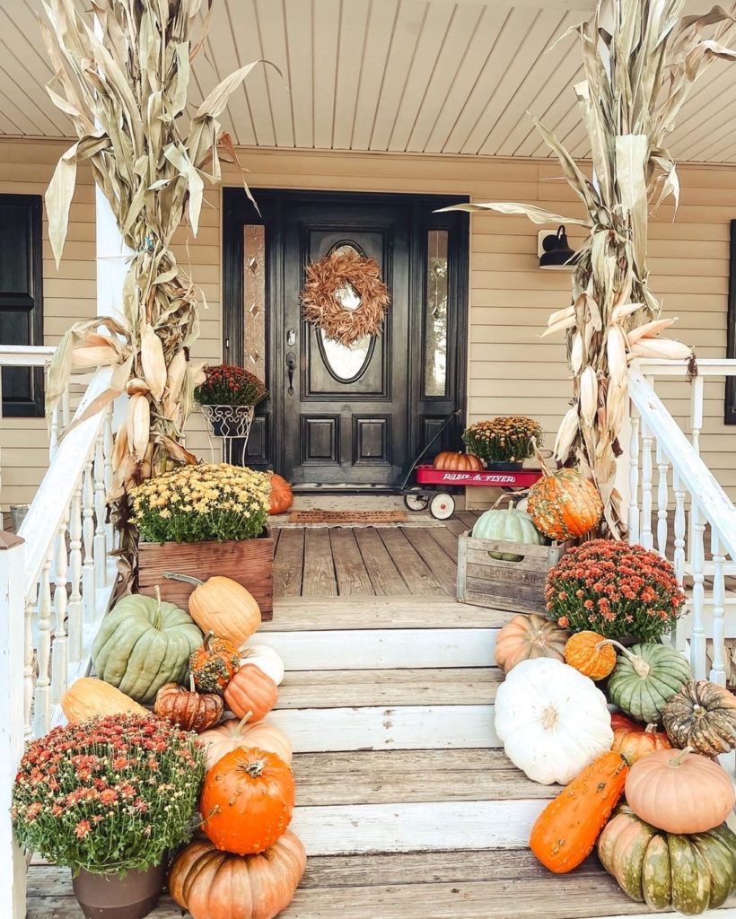 fall front porch inspiration on an old wooden front porch with pumpkins mums and gourds in a radio flyer wagon