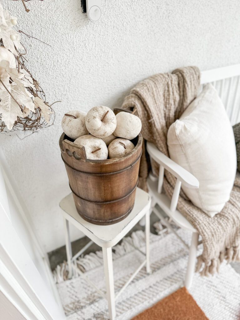 Easy ways to make a cozy fall front porch | Fall decor on the front porch | Making a festive front porch | Decorating for fall on the porch | Using faux pumpkins on the porch | A fall doormat and rug | Fall pillows to decorate your front porch | Faux apples 